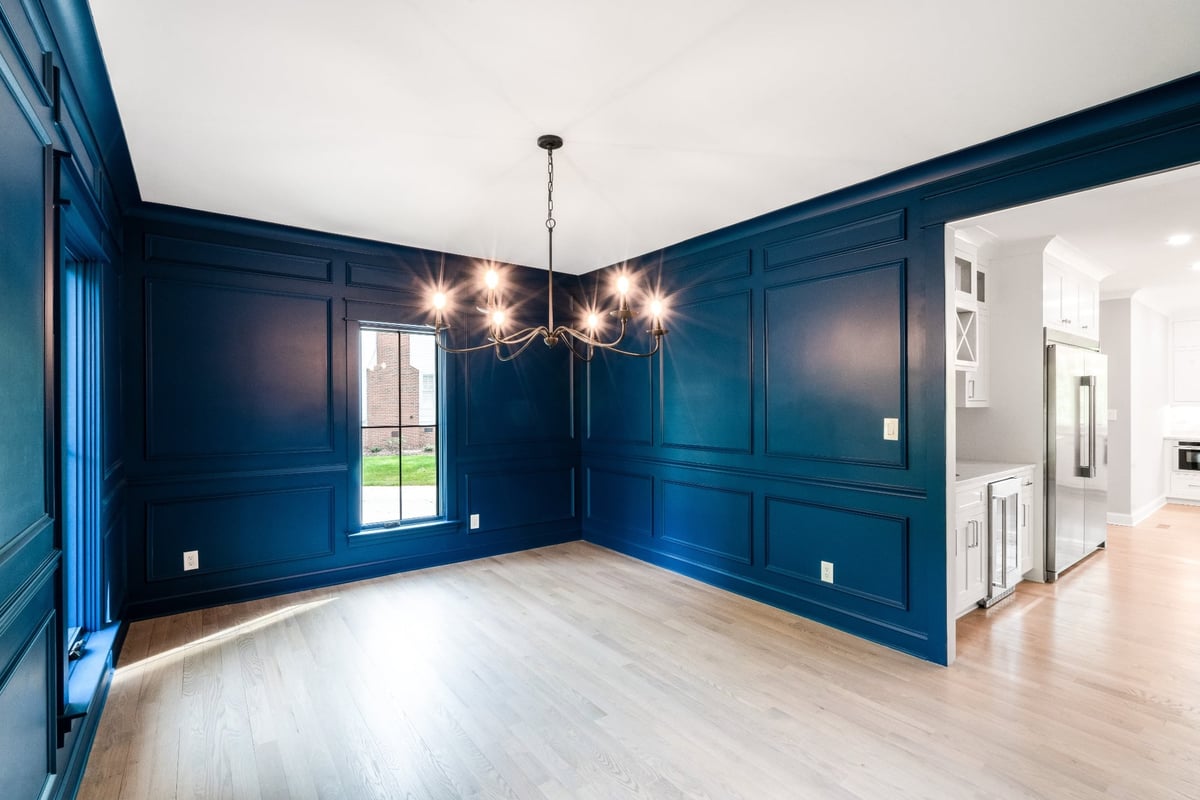 blue paneled dining room opening to a bright white kitchen in a custom home in charlotte nc