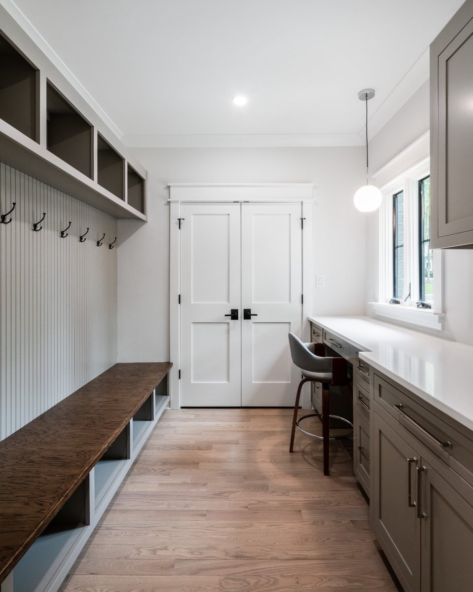 custom mudroom with built in bench storage desk and gray cabinetry in a custom home in charlotte nc