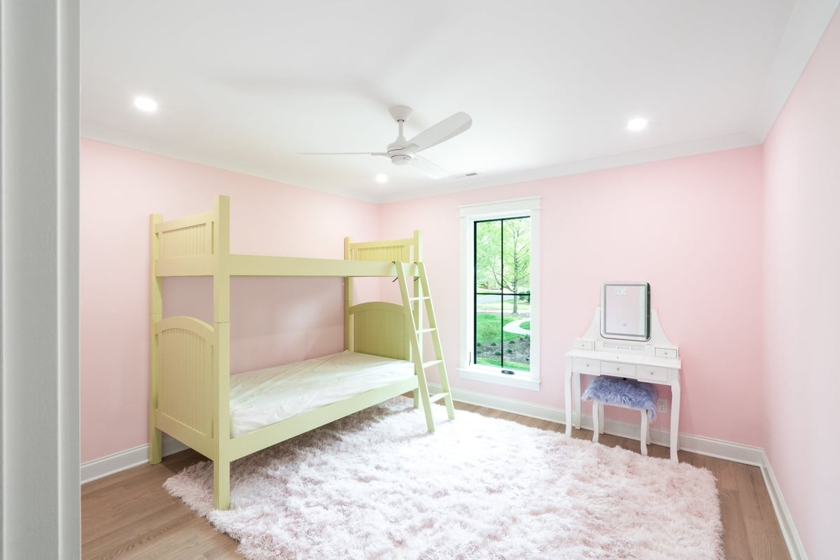 pink bedroom with built in bunk bed white vanity and hardwood floors in a custom home in charlotte nc