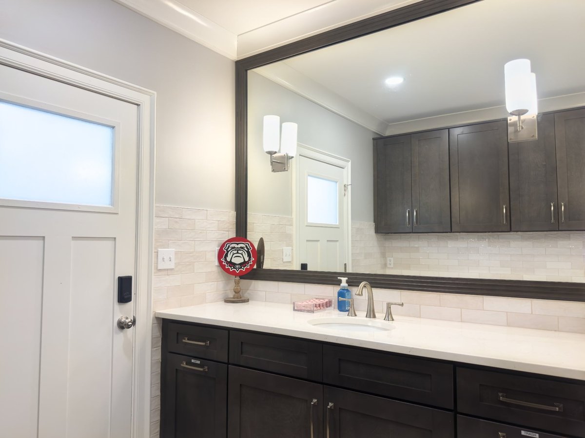 charlotte nc home project bathroom vanity with dark shaker cabinets white countertop and large framed mirror