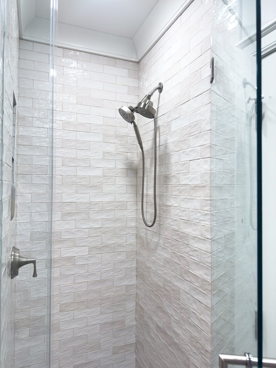 charlotte nc home project close view of white tiled walk in shower with dual showerheads and glass enclosure