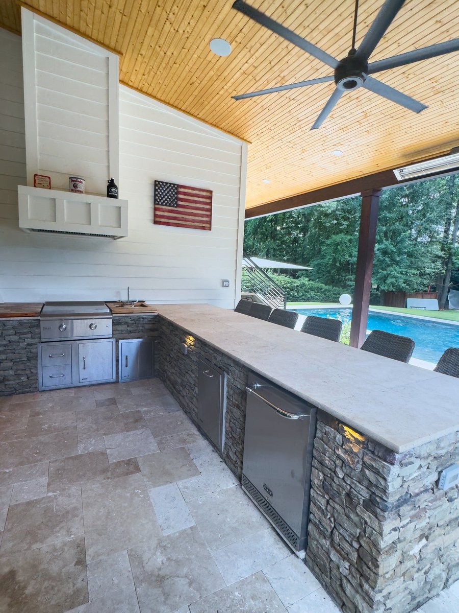 charlotte nc home project covered outdoor kitchen with long stone bar stainless appliances and pool view