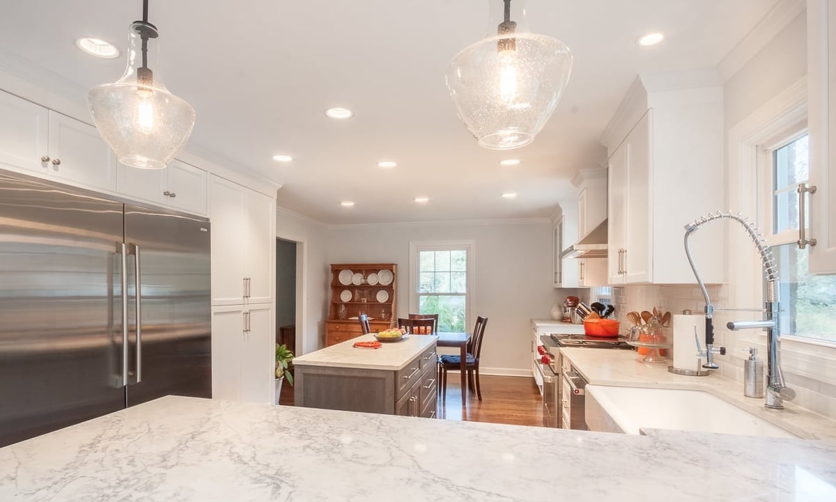 kitchen remodel with farmhouse sink quartz countertops stainless refrigerator and gray island in charlotte nc