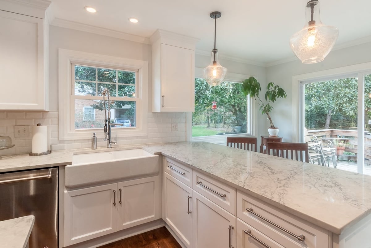 kitchen remodel with farmhouse sink white cabinets quartz peninsula and pendant lights in charlotte nc