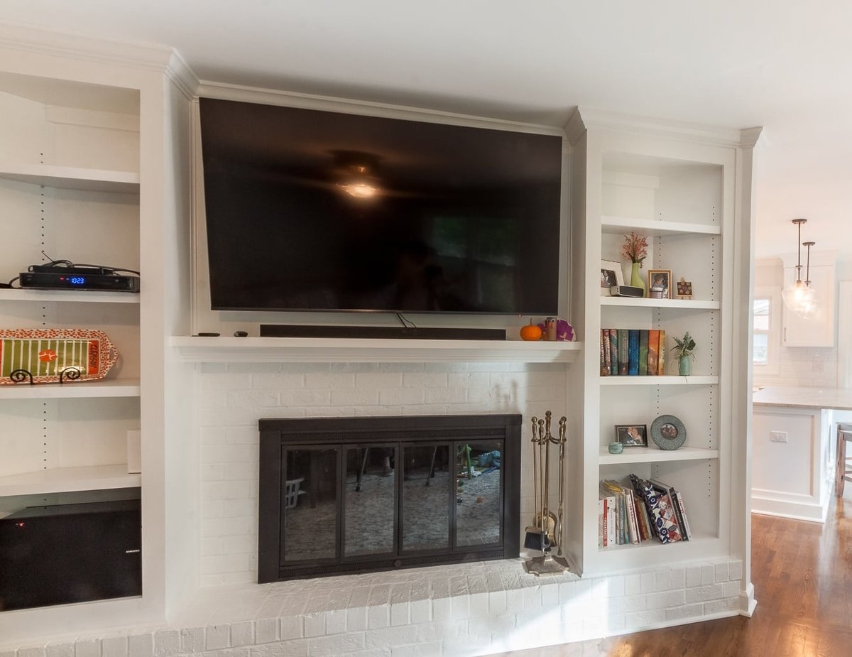 living room remodel with white brick fireplace built in shelving and wall mounted television in charlotte nc