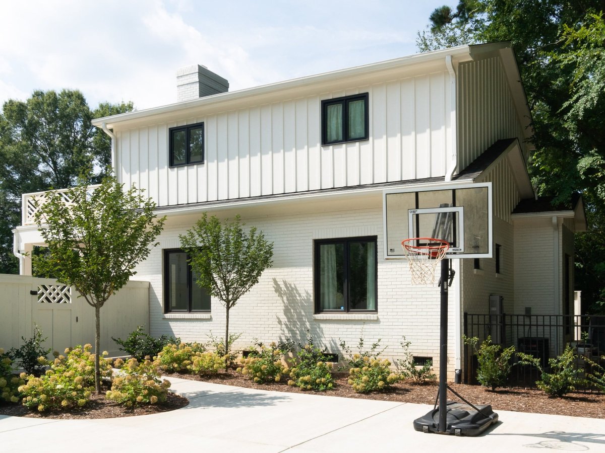 custom home guest house exterior with white siding landscaping and basketball court in charlotte nc