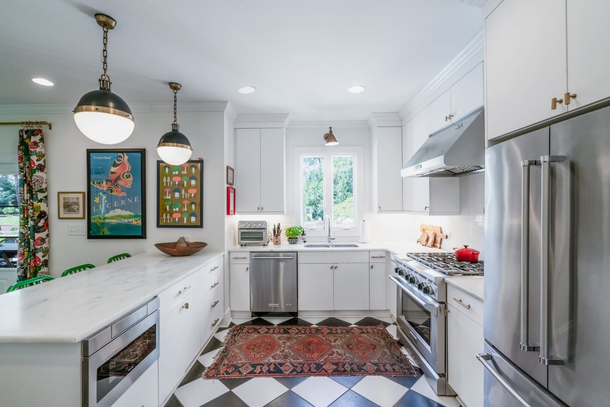 custom home kitchen with marble island white cabinetry stainless dishwasher and colorful artwork in charlotte nc
