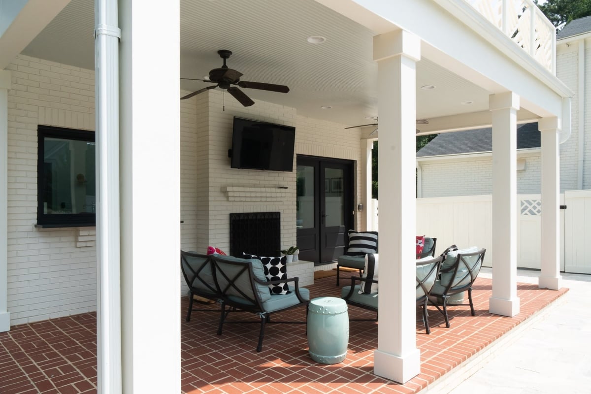 custom home pool house covered patio with white brick fireplace television and outdoor seating in charlotte nc