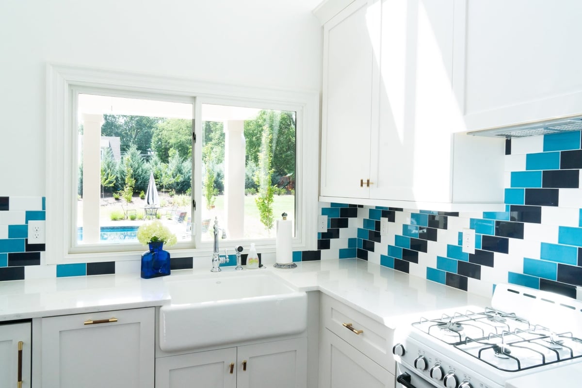 custom home pool house kitchenette with farmhouse sink white cabinets and blue black tile backsplash in charlotte nc-1