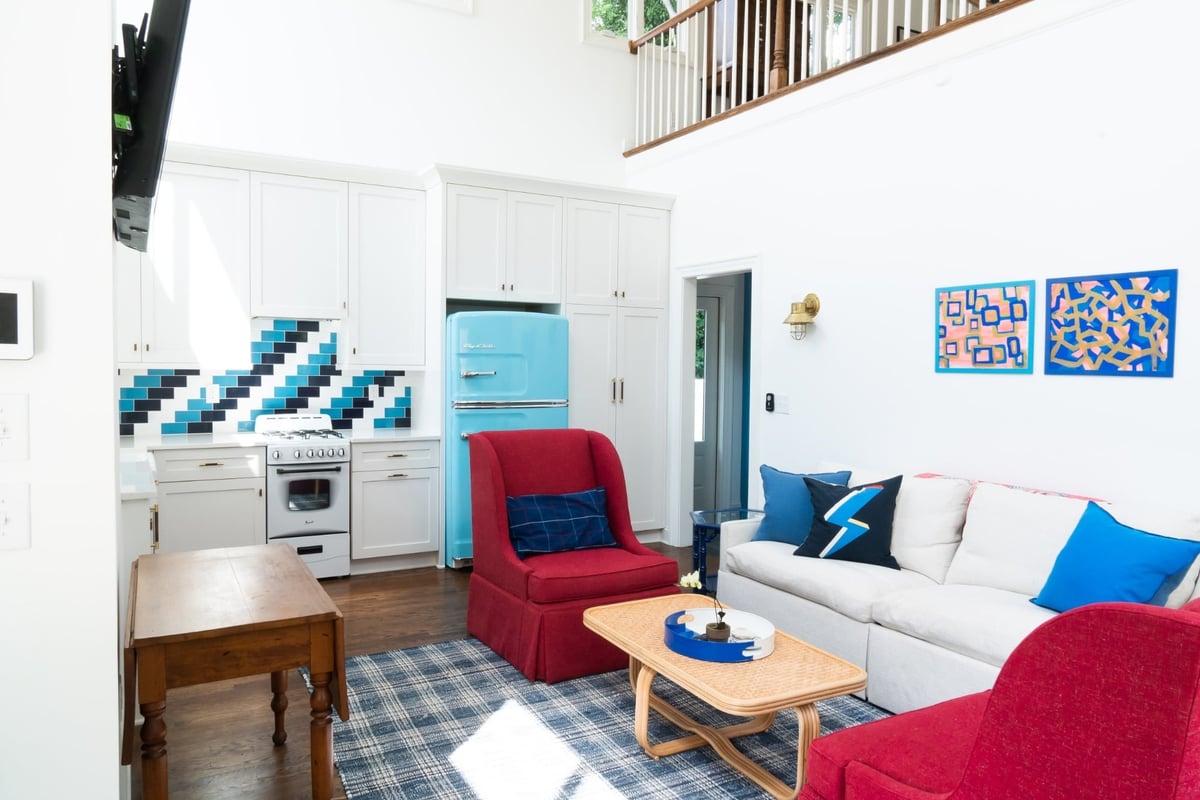 custom home pool house living room with turquoise refrigerator red chairs and white sofa in charlotte nc