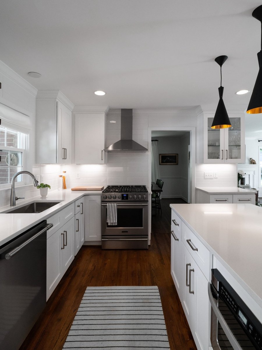 kitchen remodel with stainless range white shaker cabinets quartz counters and black pendant lights in charlotte nc
