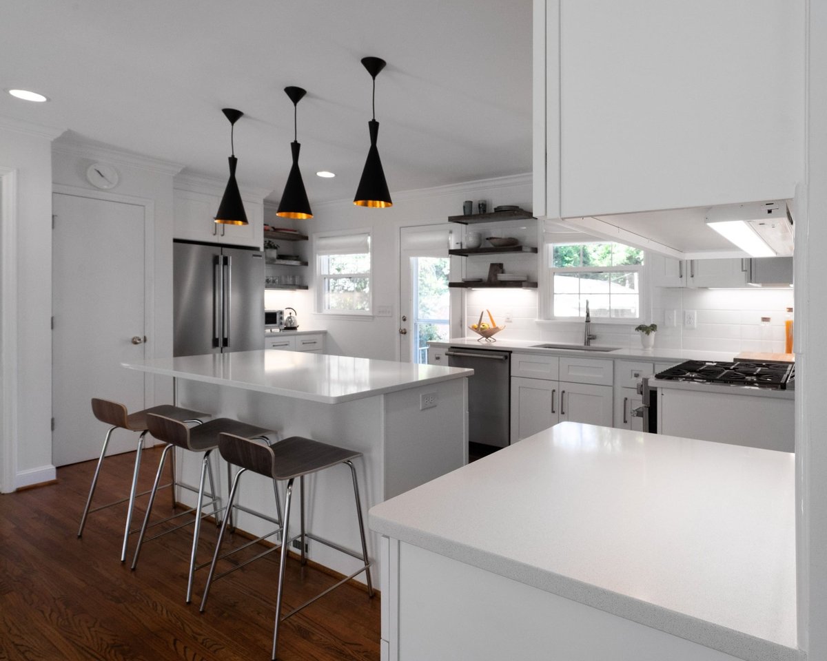 kitchen remodel with white island bar seating stainless refrigerator and black pendant lights in charlotte nc