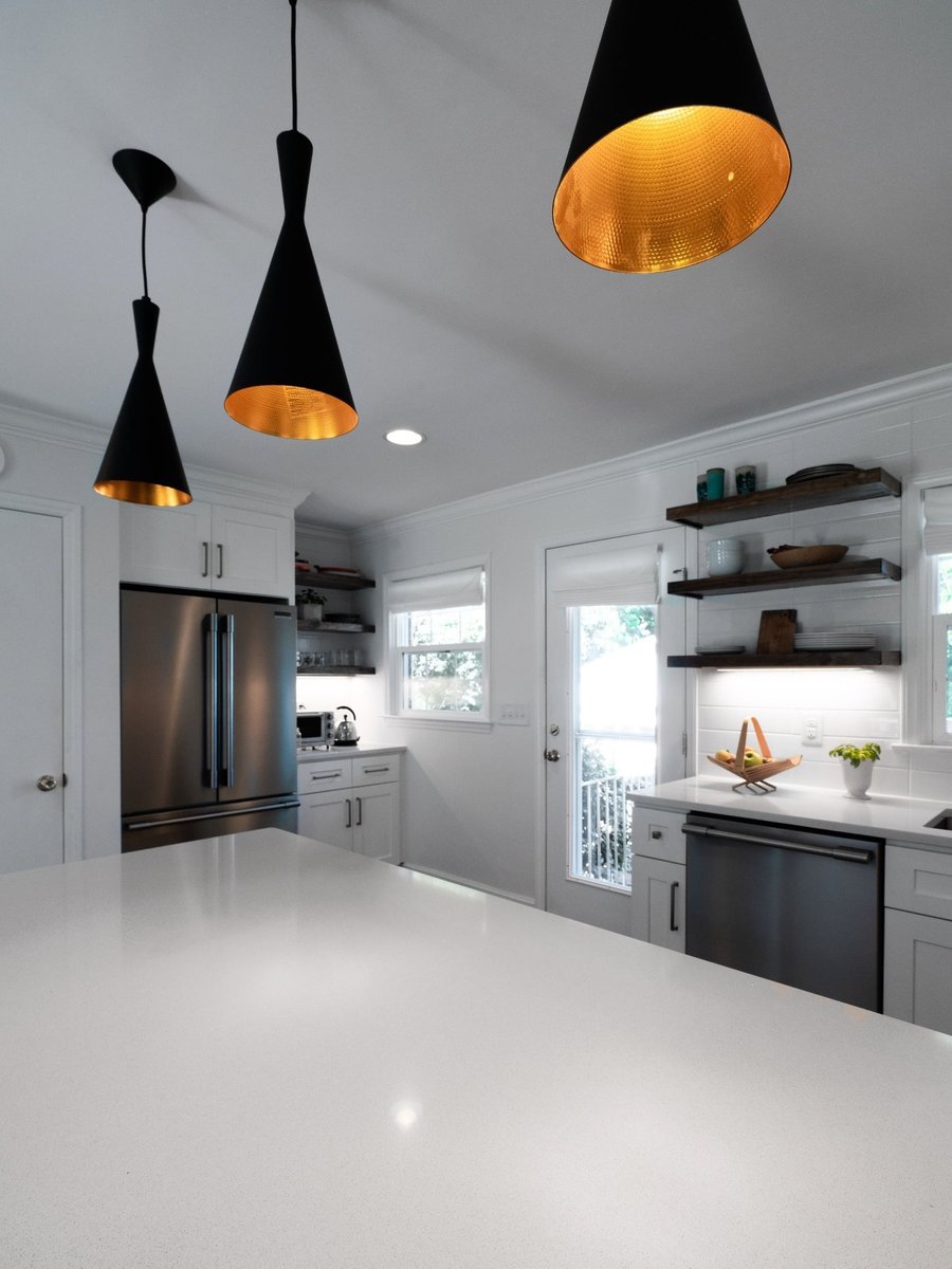 kitchen remodel with white quartz island stainless refrigerator dishwasher and black pendant lights in charlotte nc
