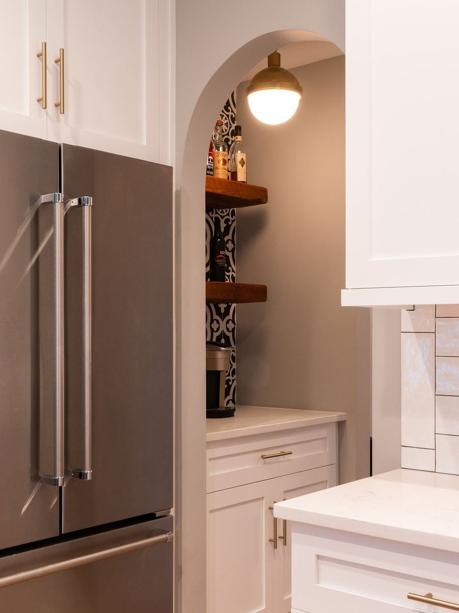 arched butlers pantry with patterned tile wood shelves and white cabinetry in a first floor remodel in fort mill sc