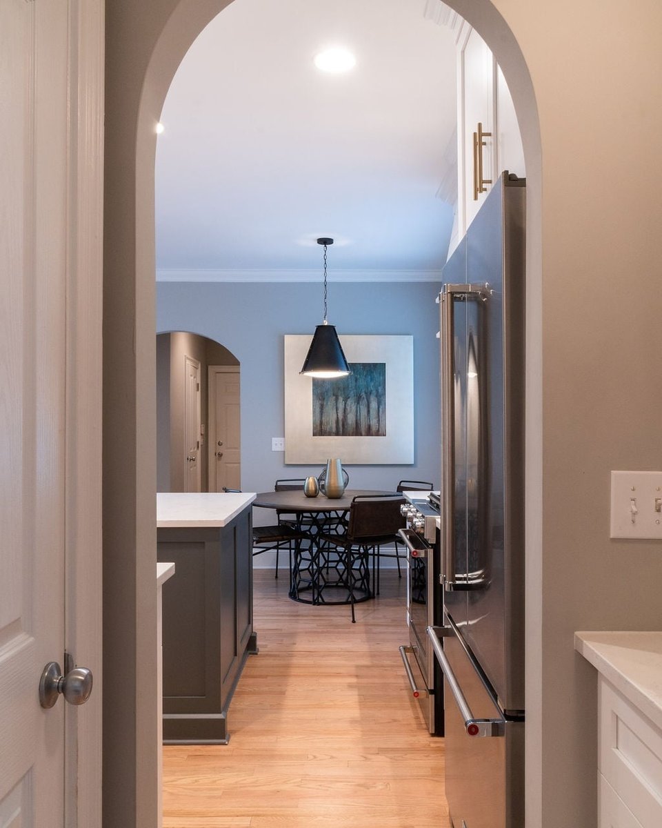 arched doorway view into remodeled kitchen and breakfast nook in a first floor remodel in fort mill sc