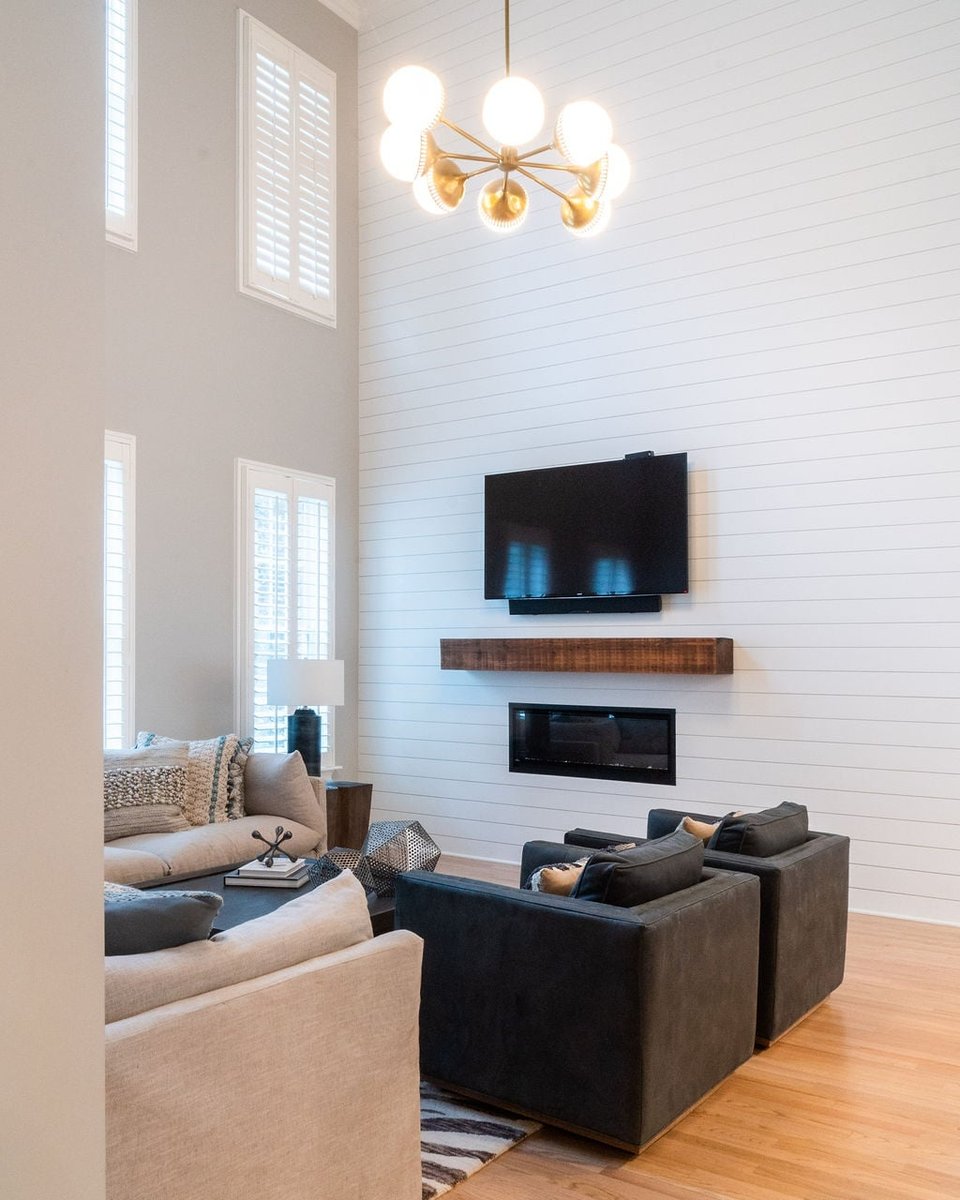 bright two story living room with modern chandelier and shiplap fireplace in a first floor remodel in fort mill sc