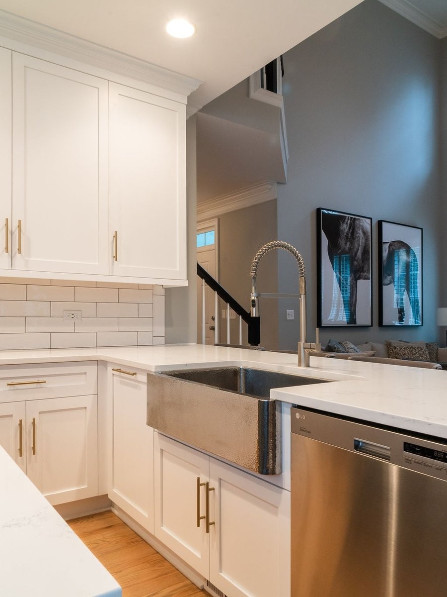 first floor remodel kitchen with hammered farmhouse sink white cabinets brass hardware and quartz counters in fort mill sc