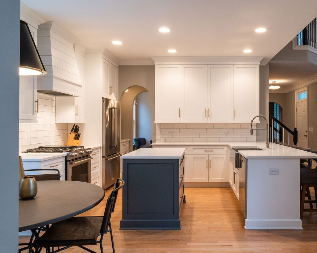 first floor remodel kitchen with white cabinetry navy island quartz countertops and open dining area in fort mill sc