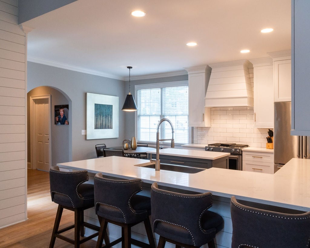 open concept kitchen with large white quartz peninsula and gray cabinetry in a first floor remodel in fort mill sc