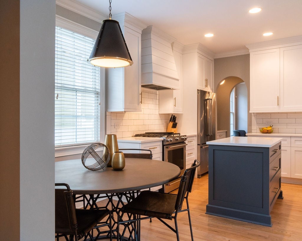 white kitchen with gray island and breakfast table in a first floor remodel in fort mill sc