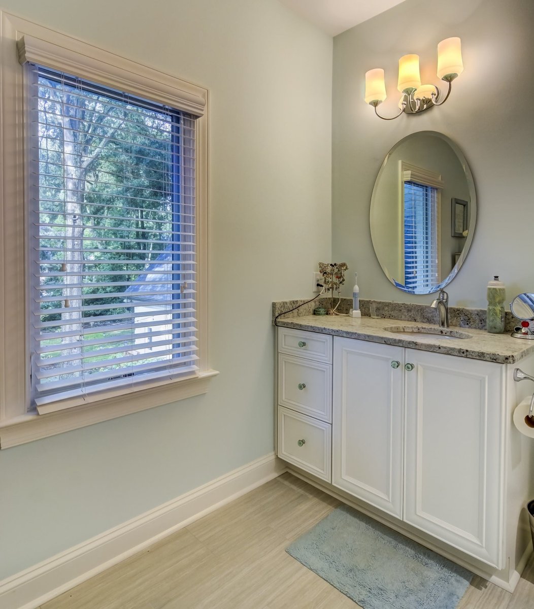 bathroom vanity with granite countertop and oval mirror in charlotte nc whole home remodel