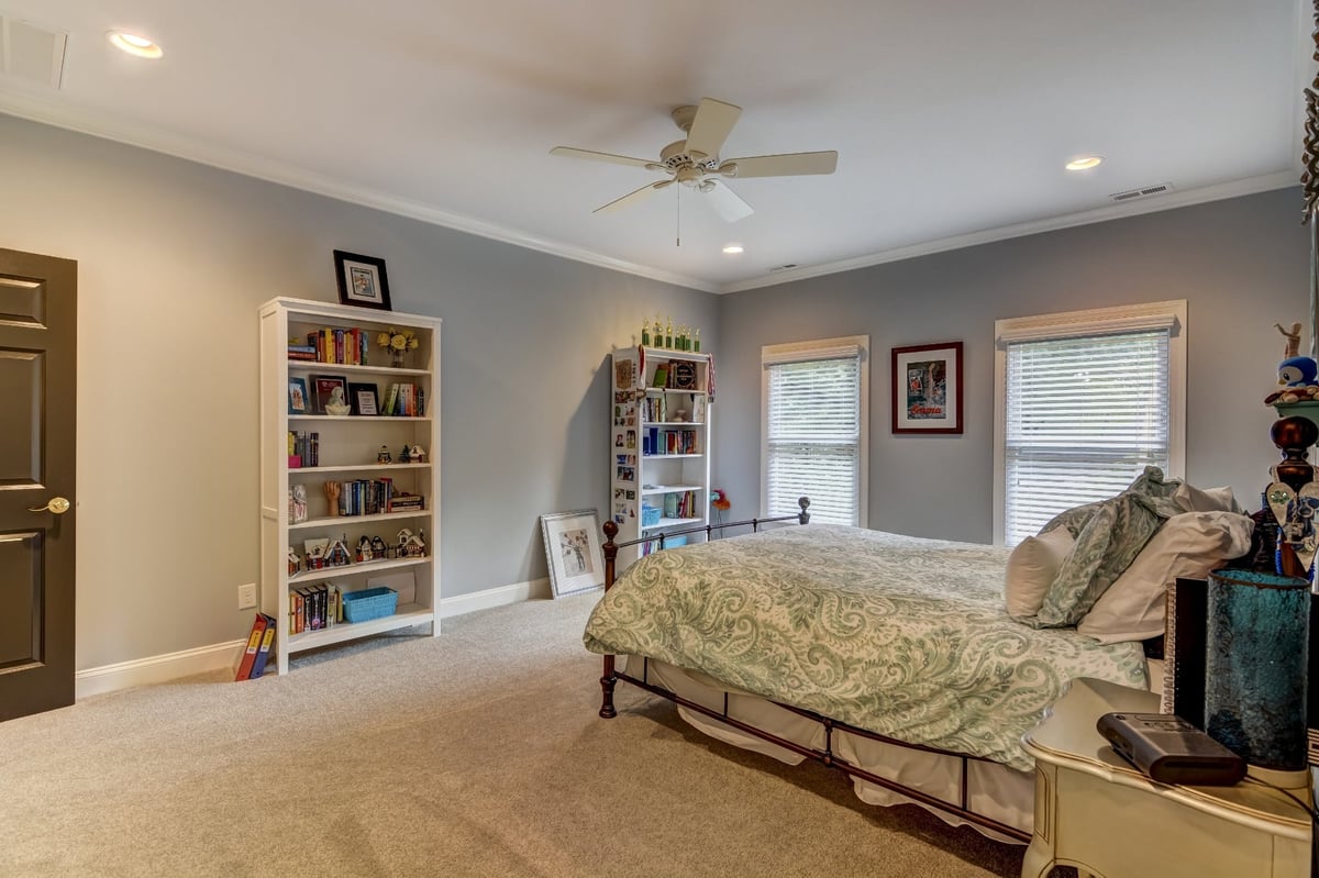 bedroom with iron bed bookshelves and large windows in charlotte nc whole home remodel