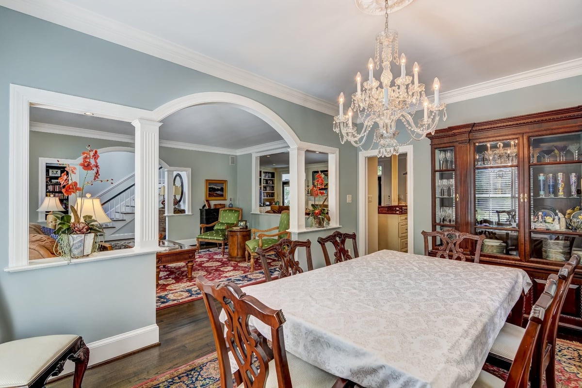 formal dining room with crystal chandelier china cabinet and arched opening in charlotte nc whole home remodel