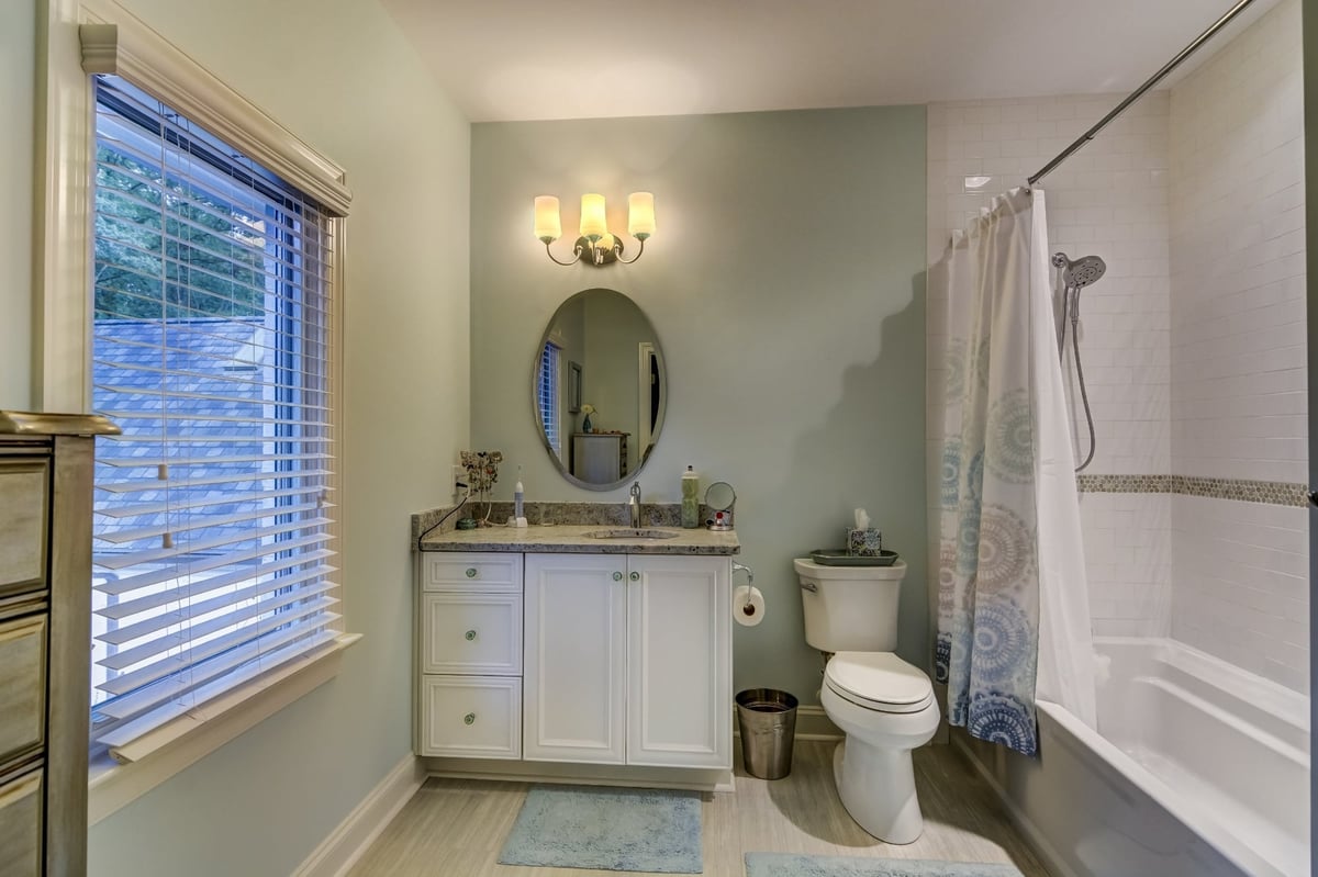 light green bathroom with white vanity and tiled tub in charlotte nc whole home remodel