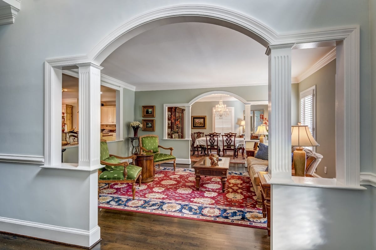 living room framed by arched columns with red rug and traditional furnishings in charlotte nc whole home remodel
