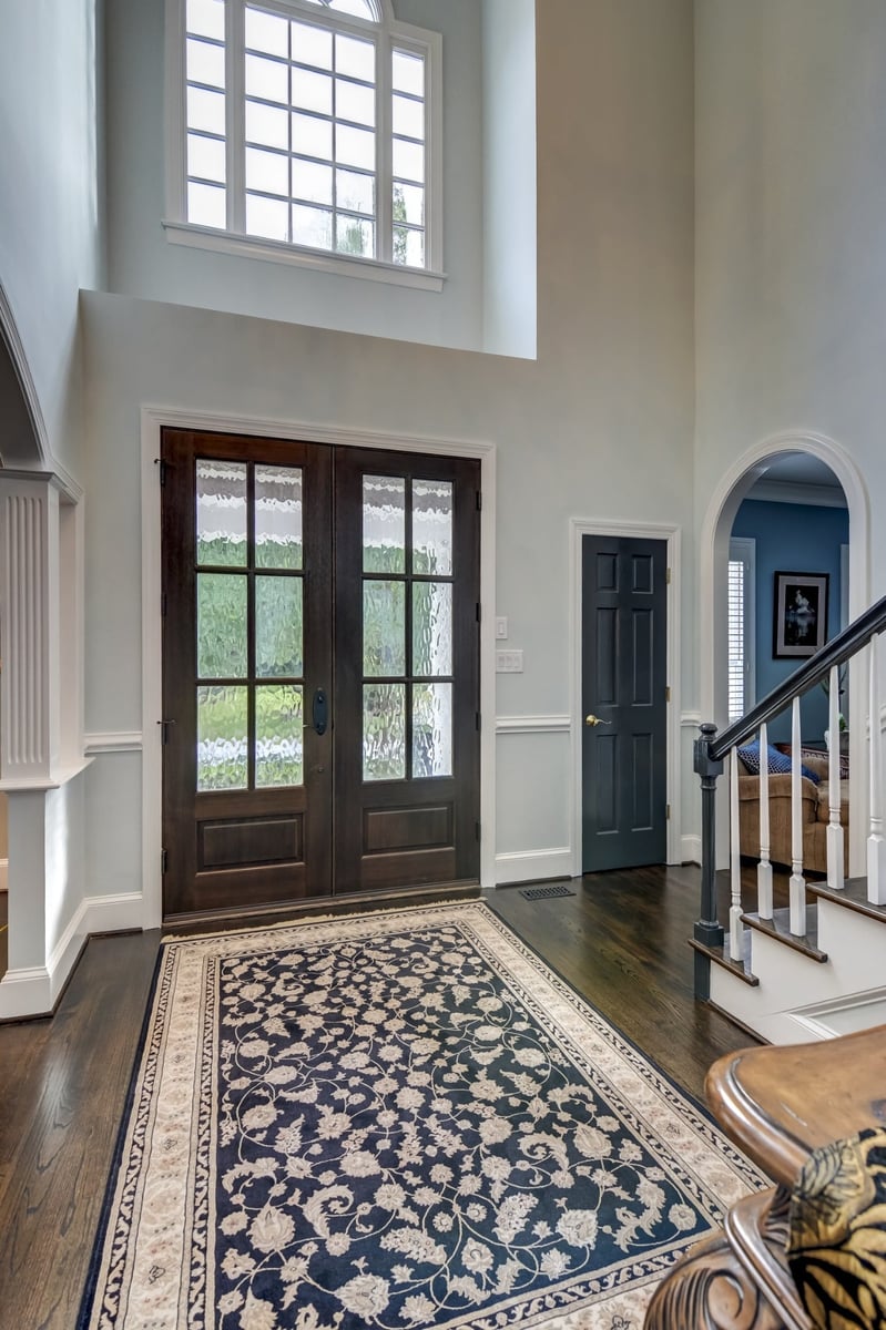 tall foyer with dark wood double doors patterned glass and staircase in charlotte nc whole home remodel