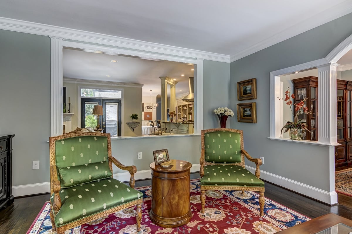 traditional living room with green armchairs and openings to kitchen and dining room in charlotte nc whole home remodel