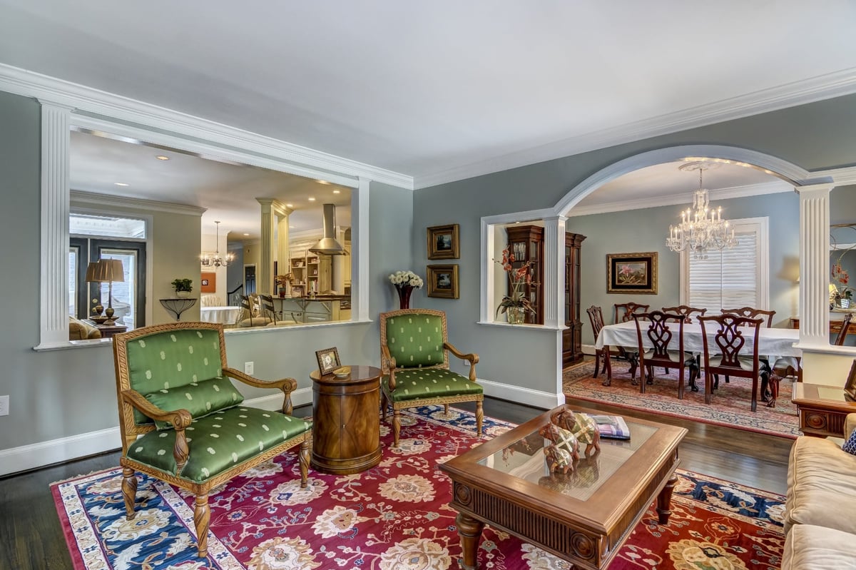 traditional living room with green armchairs red rug and open dining room in charlotte nc whole home remodel