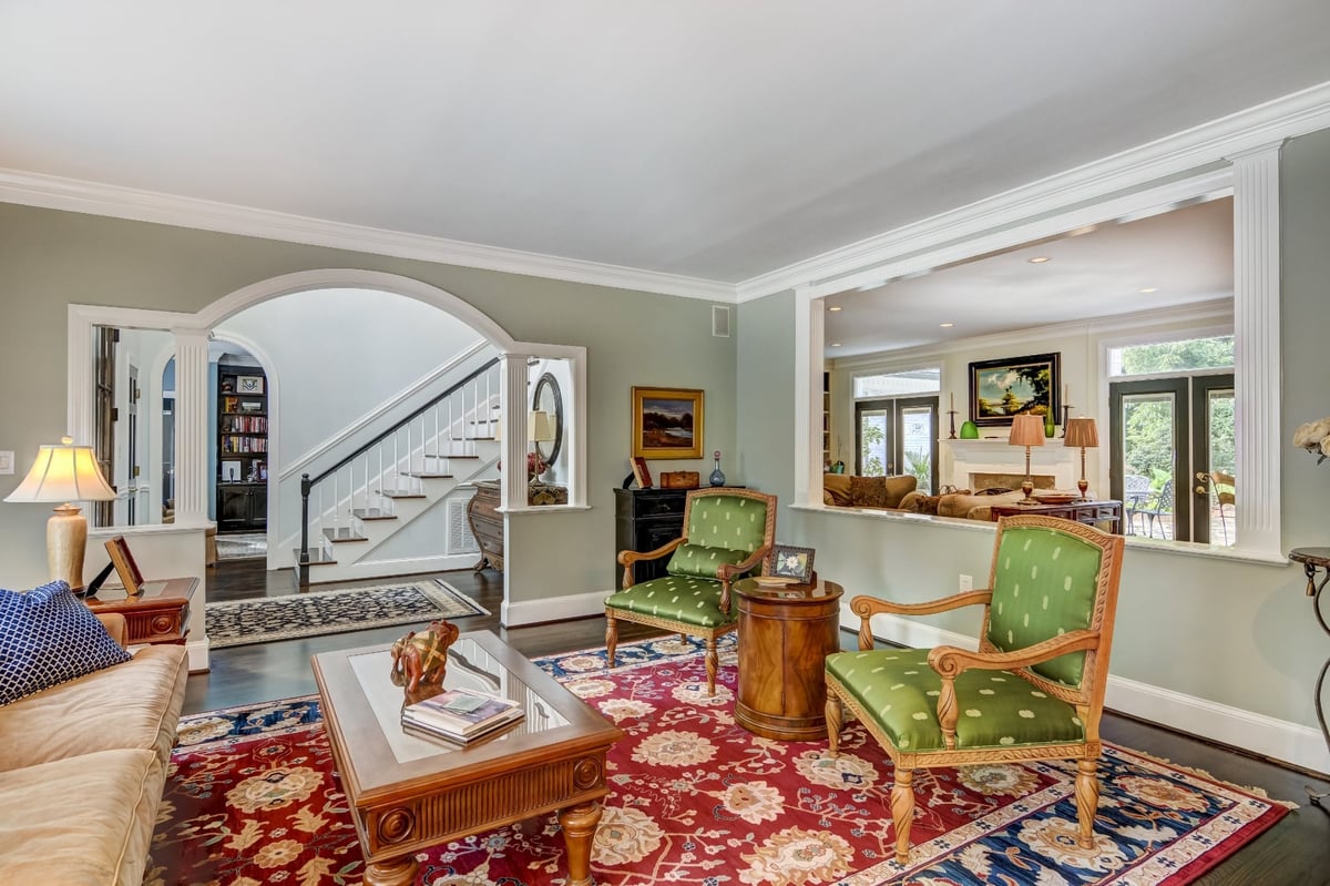 traditional living room with staircase view green chairs and red area rug in charlotte nc whole home remodel