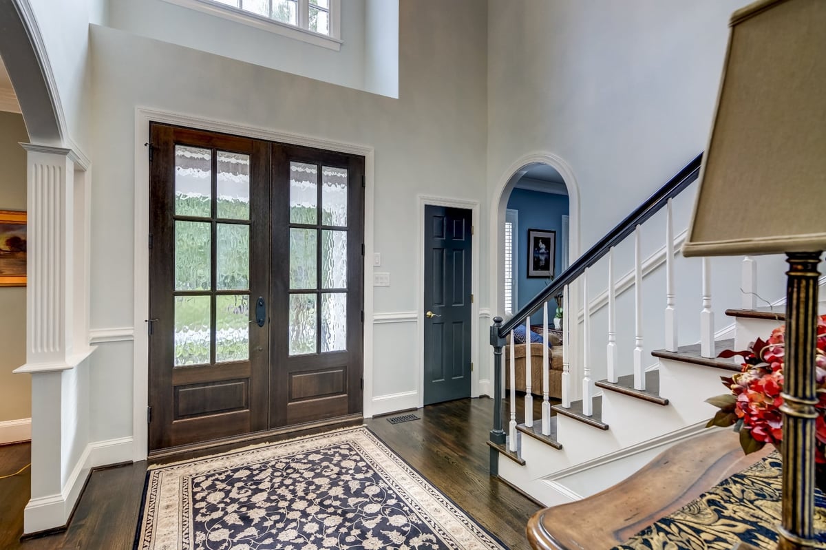 two story foyer with dark wood double entry doors and staircase in charlotte nc whole home remodel