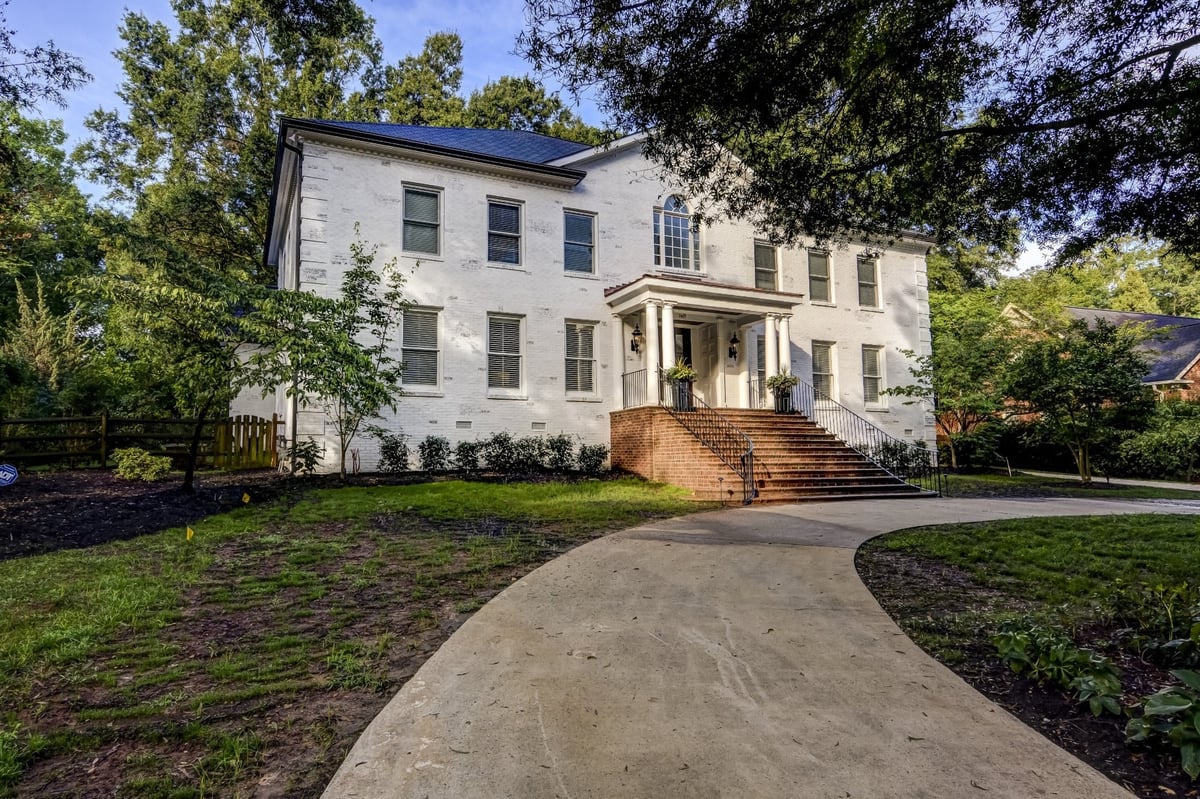 white brick two story home with columned front porch in charlotte nc whole home remodel