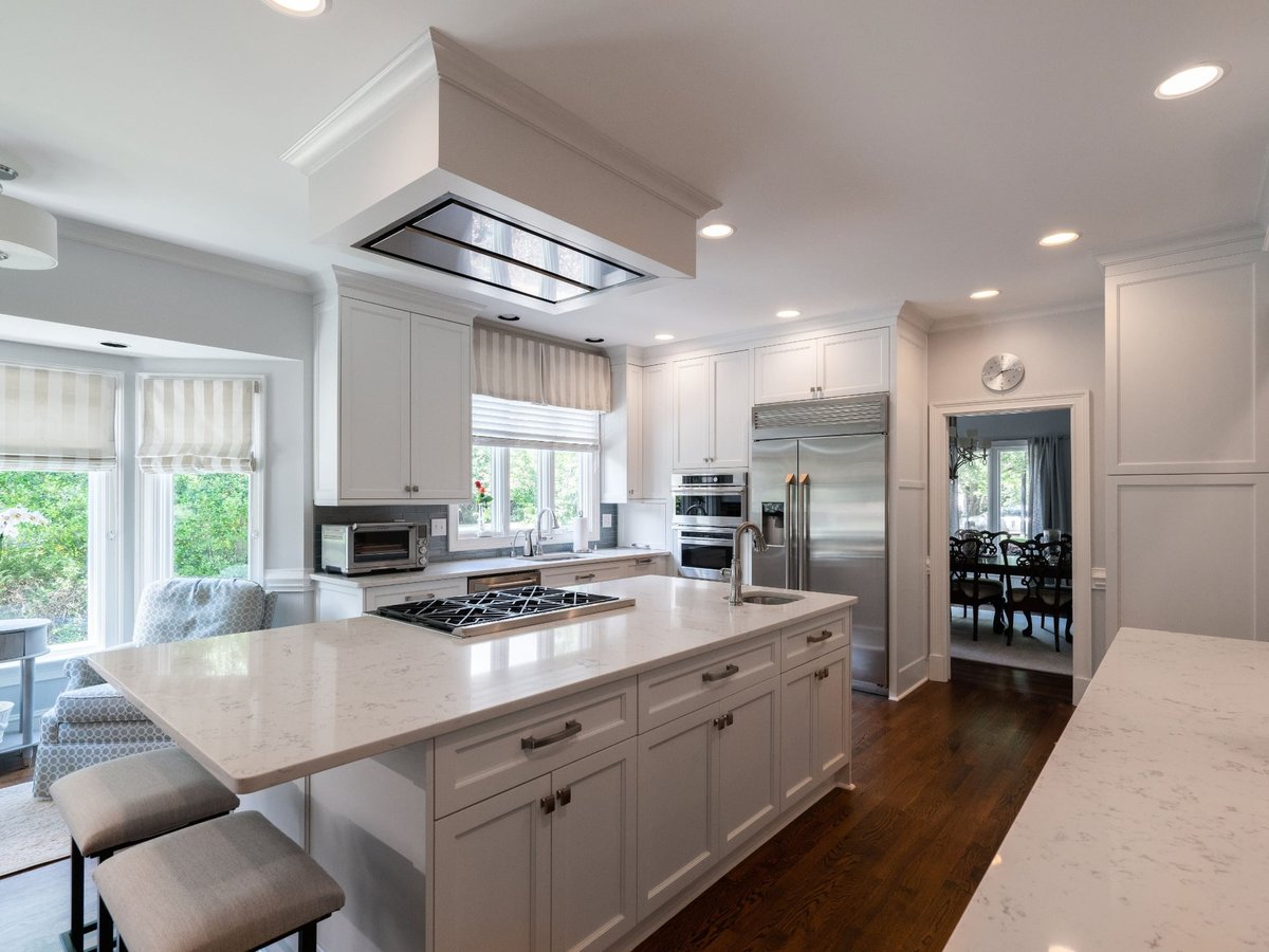 white kitchen island with cooktop and stainless appliances in charlotte nc first floor remodel