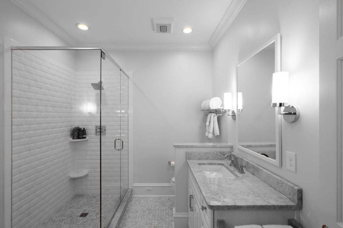 bright white bathroom with glass shower marble vanity and mosaic tile floor in charlotte nc whole home remodel