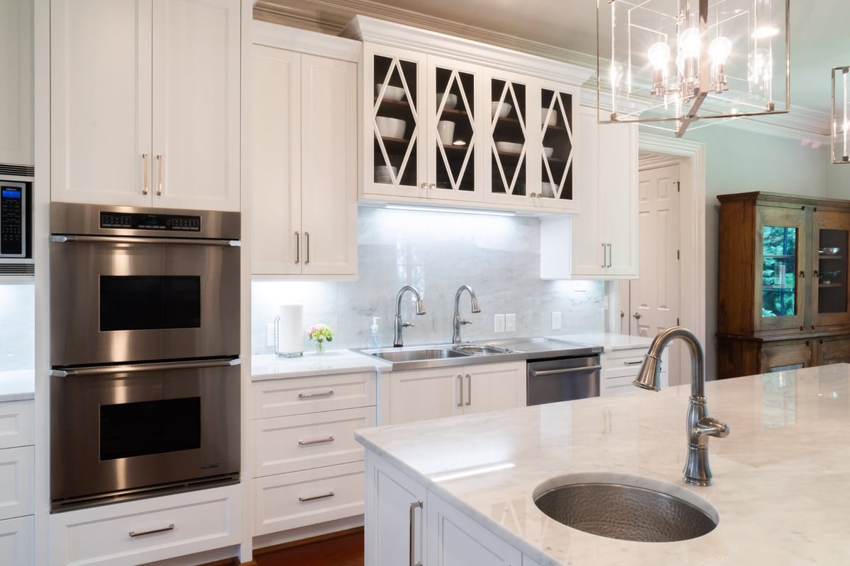 custom white kitchen with marble island double ovens and glass cabinets in charlotte nc whole home remodel