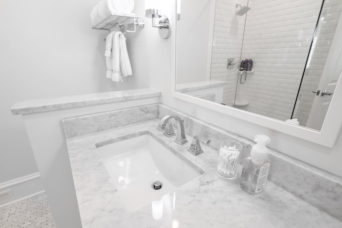 marble bathroom sink vanity with chrome fixtures and glass shower in charlotte nc whole home remodel