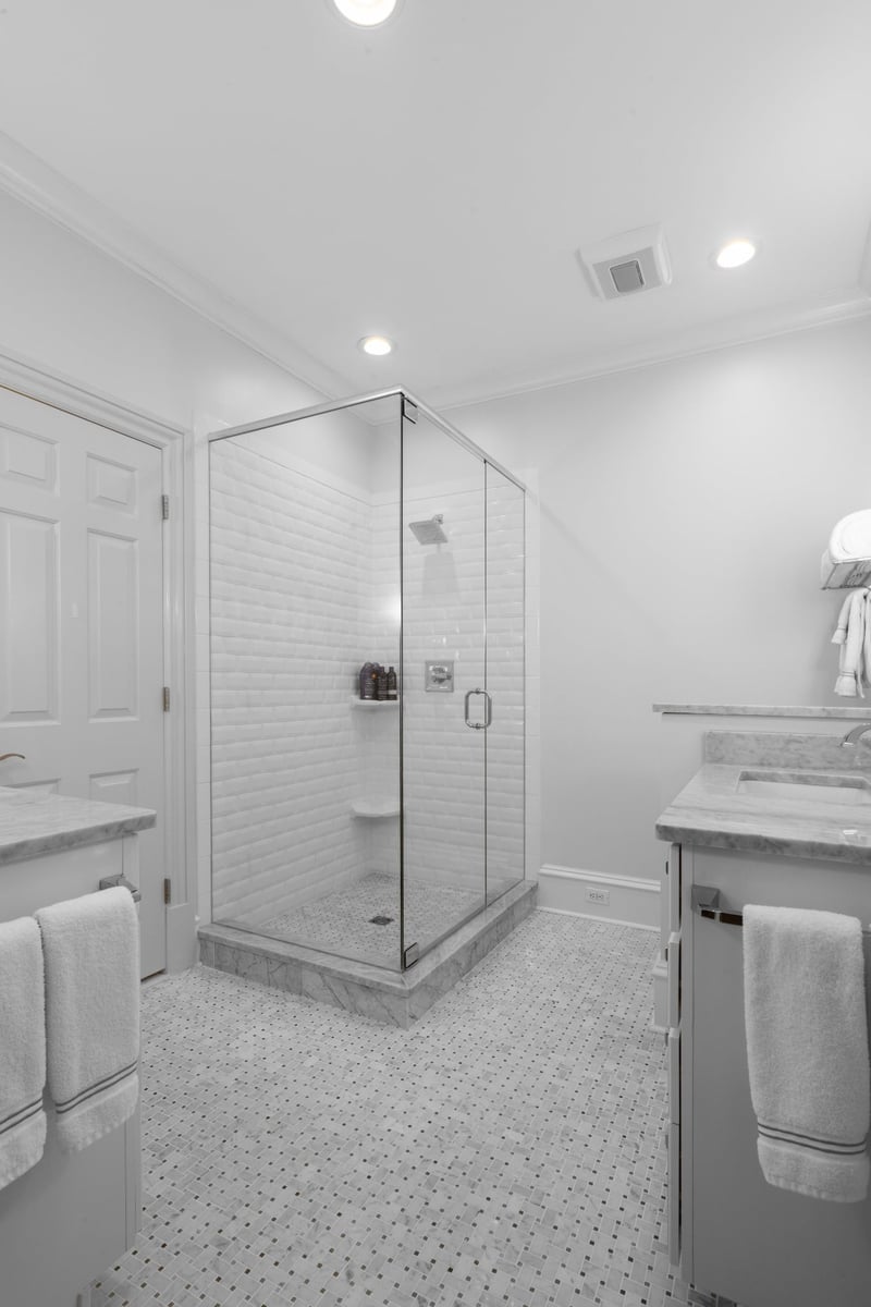 white bathroom with glass shower and marble mosaic tile floor in charlotte nc whole home remodel