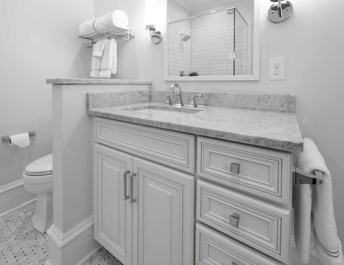 whole home remodel bathroom in charlotte nc featuring marble vanity white cabinets and chrome hardware