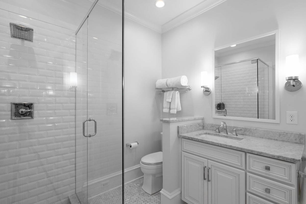 whole home remodel bathroom in charlotte nc with glass shower marble vanity and white cabinetry