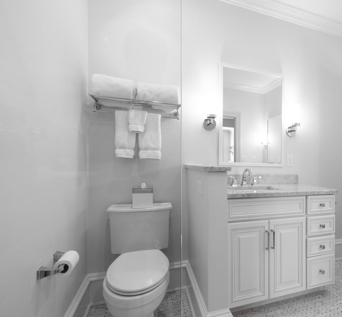 whole home remodel bathroom in charlotte nc with toilet marble vanity white cabinetry and towel rack