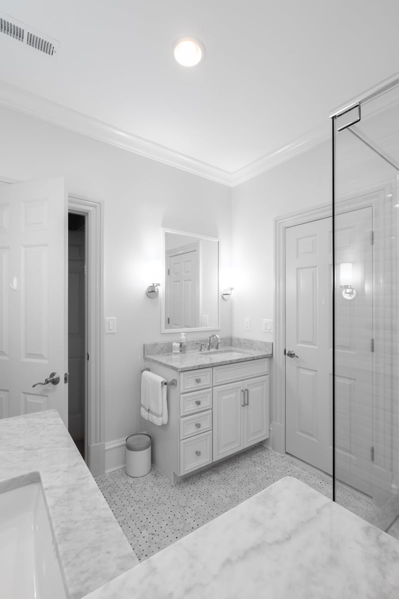 whole home remodel bathroom in charlotte nc with white vanity mosaic tile floor and glass shower