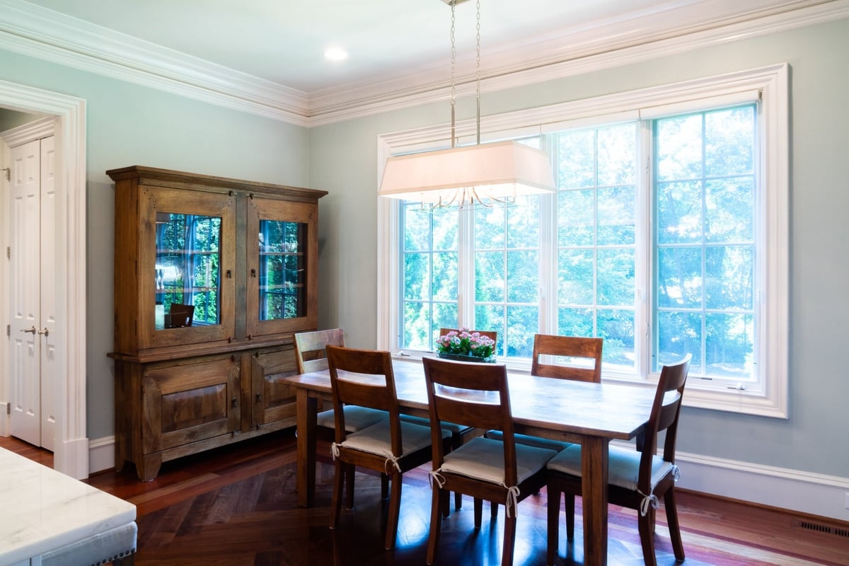 whole home remodel dining room with wood table display hutch and picture windows in charlotte nc