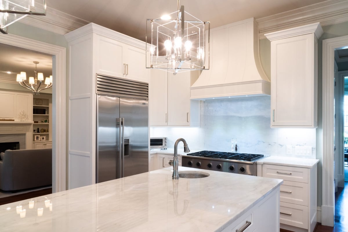 whole home remodel kitchen with stainless refrigerator range hood and marble island in charlotte nc