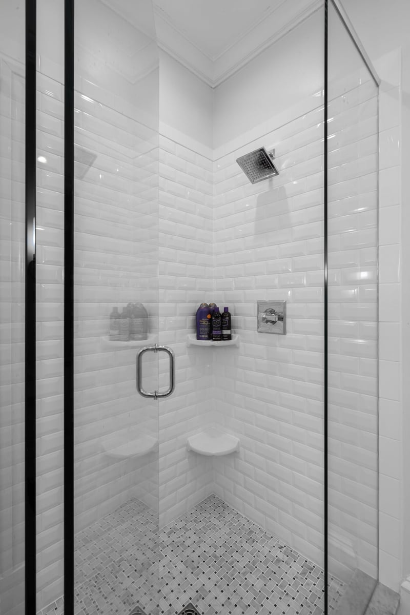 whole home remodel shower in charlotte nc with white subway tile mosaic floor and frameless glass