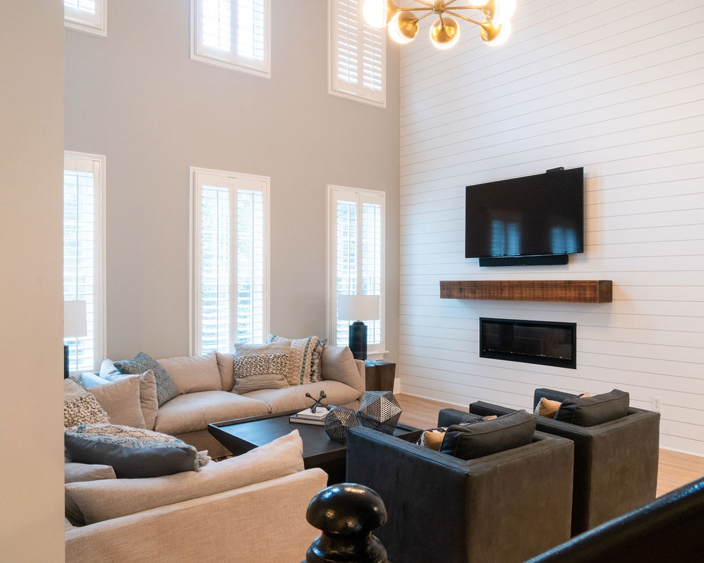 open concept living room with sectional seating fireplace and tall windows in a first floor remodel in fort mill sc