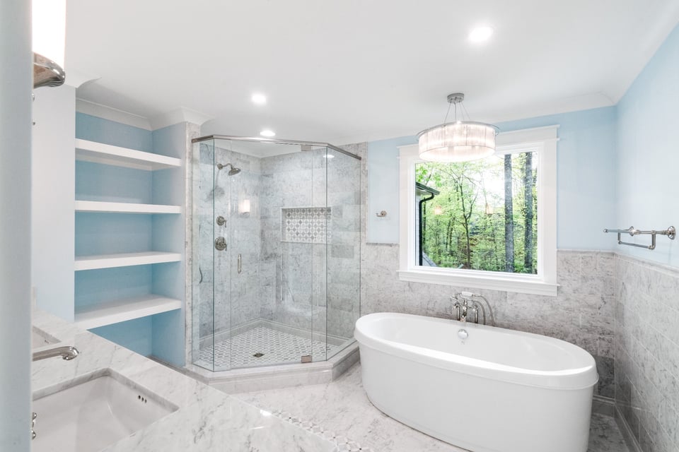 primary bathroom with marble glass shower freestanding tub and wooded view in a custom home in charlotte nc
