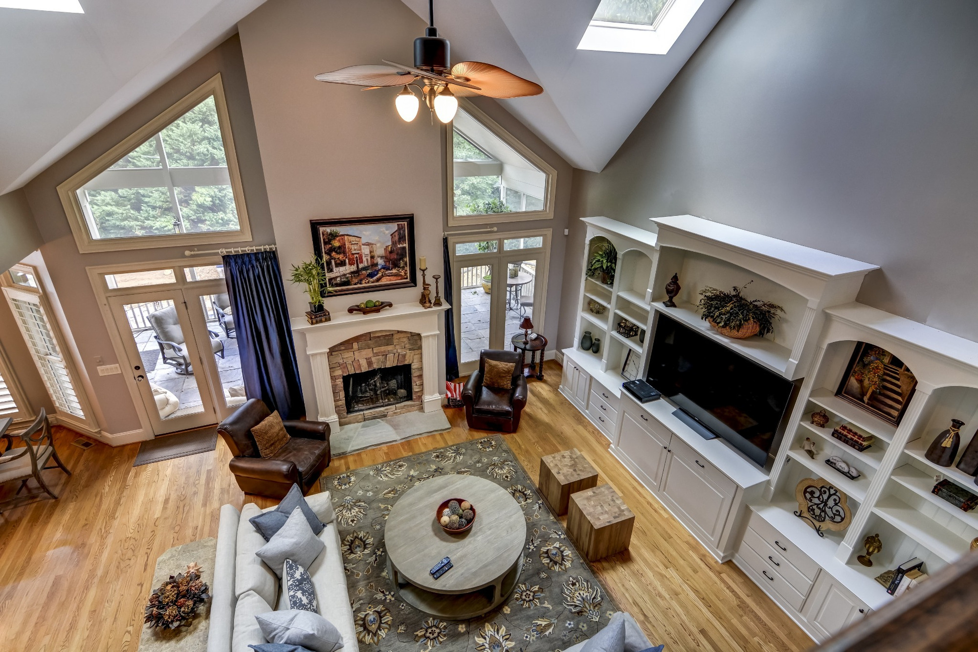 two story living room with fireplace built in media cabinets and hardwood floors in a whole home remodel in charlotte nc